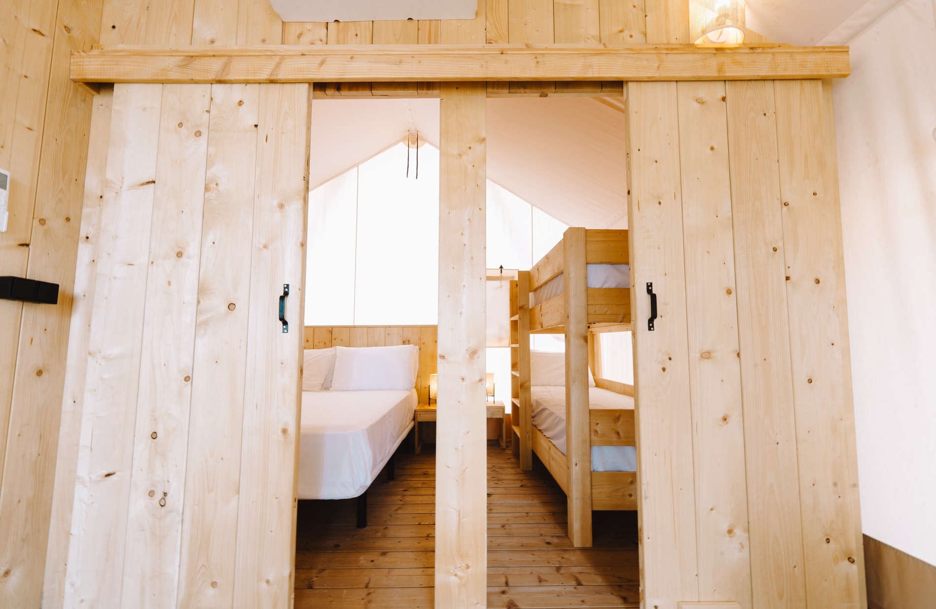 eine Holztür führt in ein Schlafzimmer mit zwei Betten