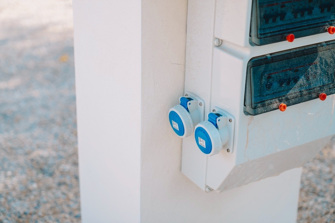 dos enchufes azules están conectados a una pared blanca