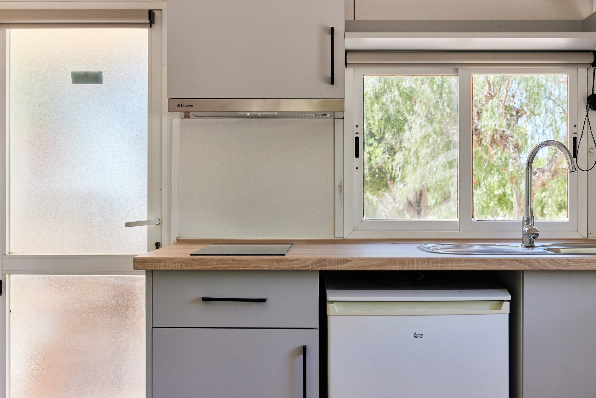 a kitchen with a white dishwasher and a window