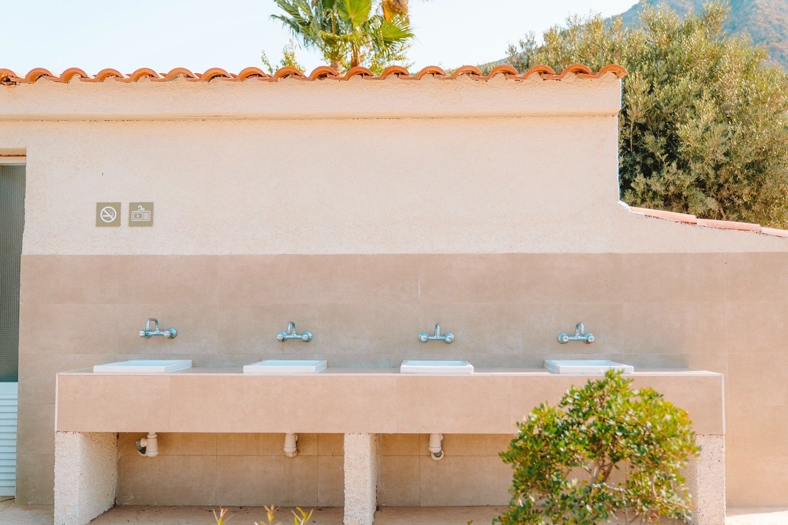 ein Badezimmer mit vielen Waschbecken und einem Schild an der Wand