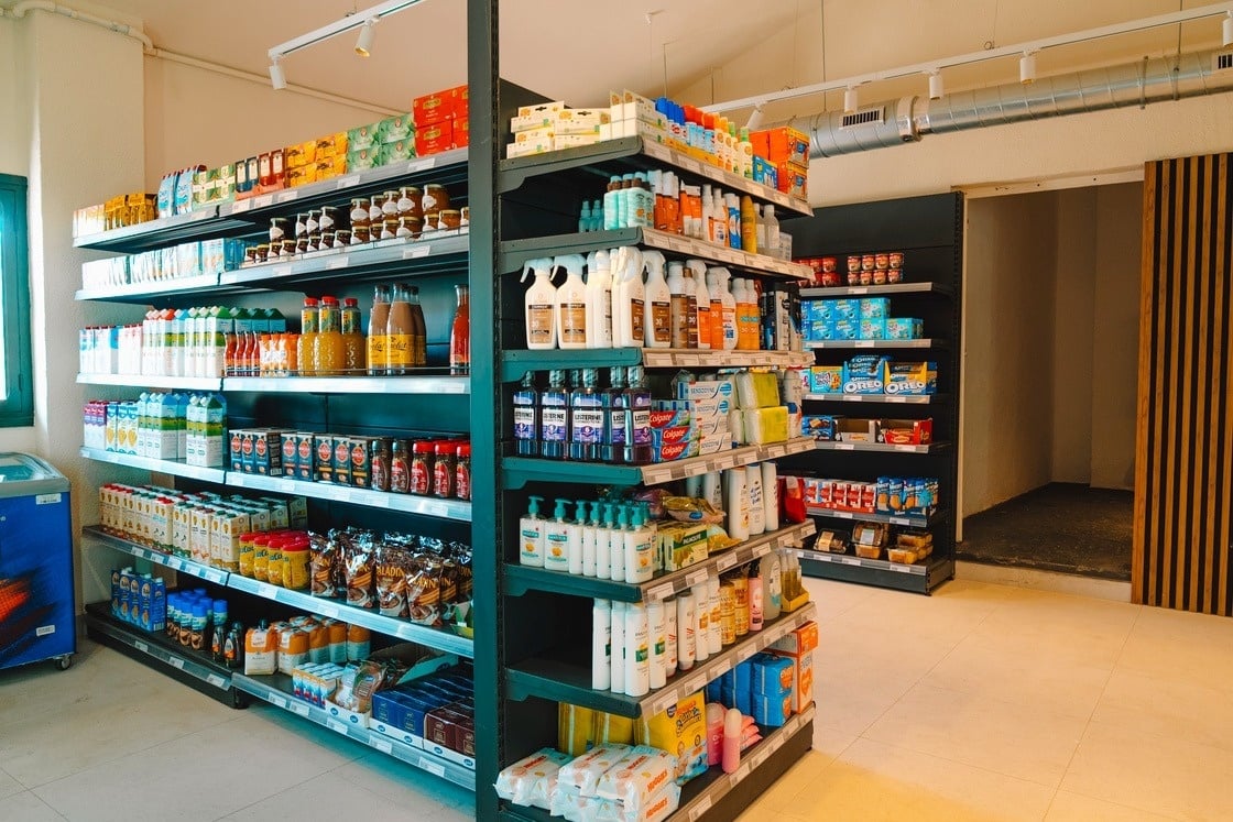 eine Frau hält einen blauen Wäschekorb voller Wäsche