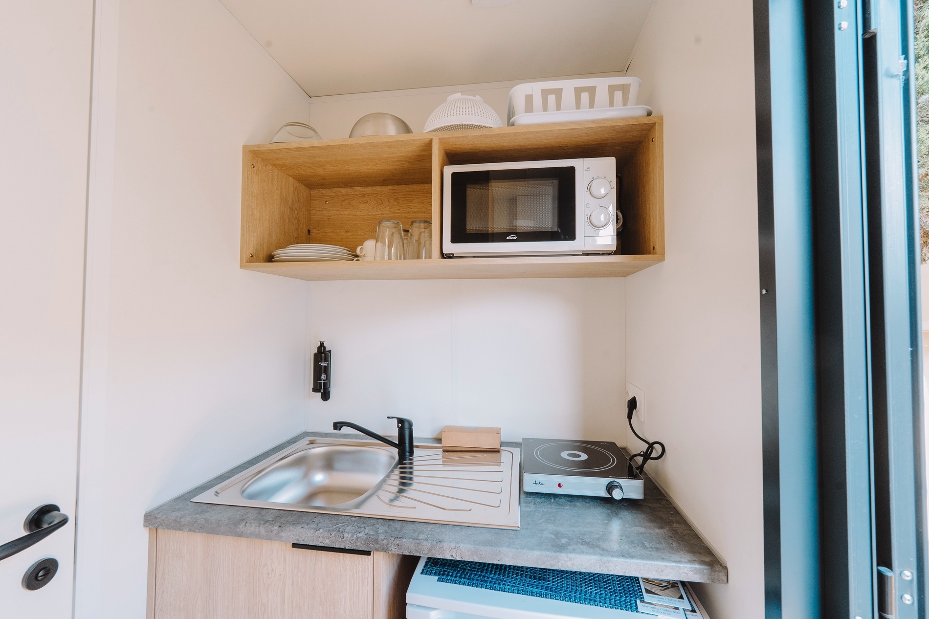eine kleine Küche mit einem Spülbecken und einem Mikrowellenherd