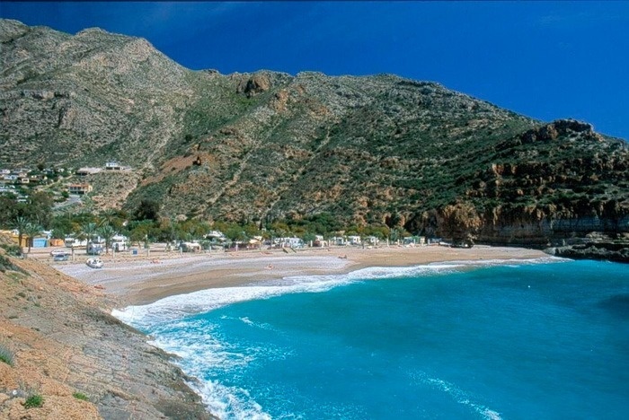 une plage entourée de montagnes et d' eau bleue
