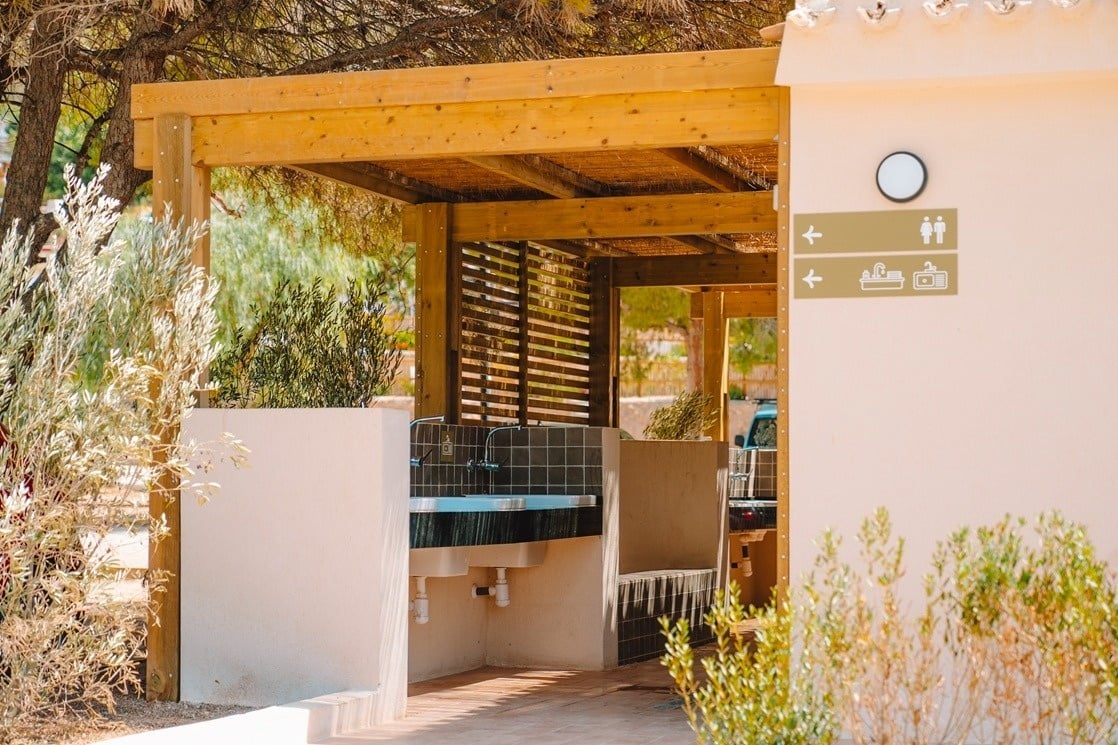 ein Badezimmer mit vielen Waschbecken und einem Schild an der Wand