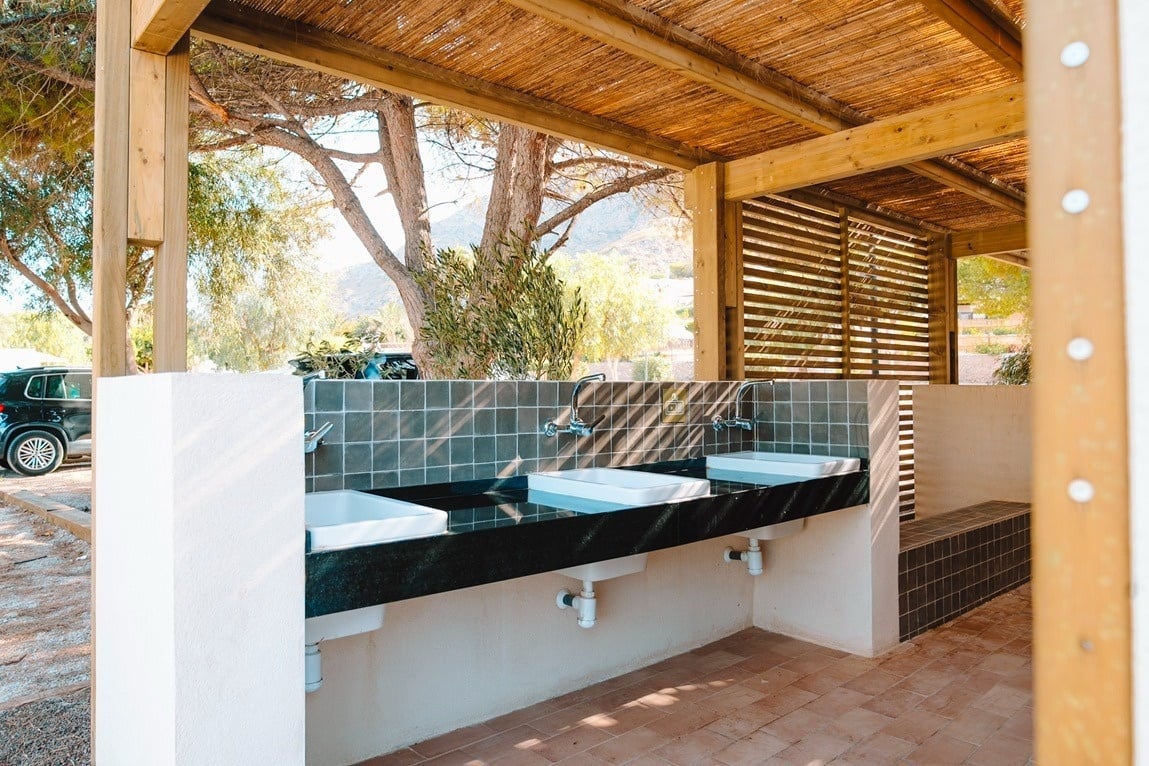 ein Badezimmer mit vielen Waschbecken und einem Schild an der Wand