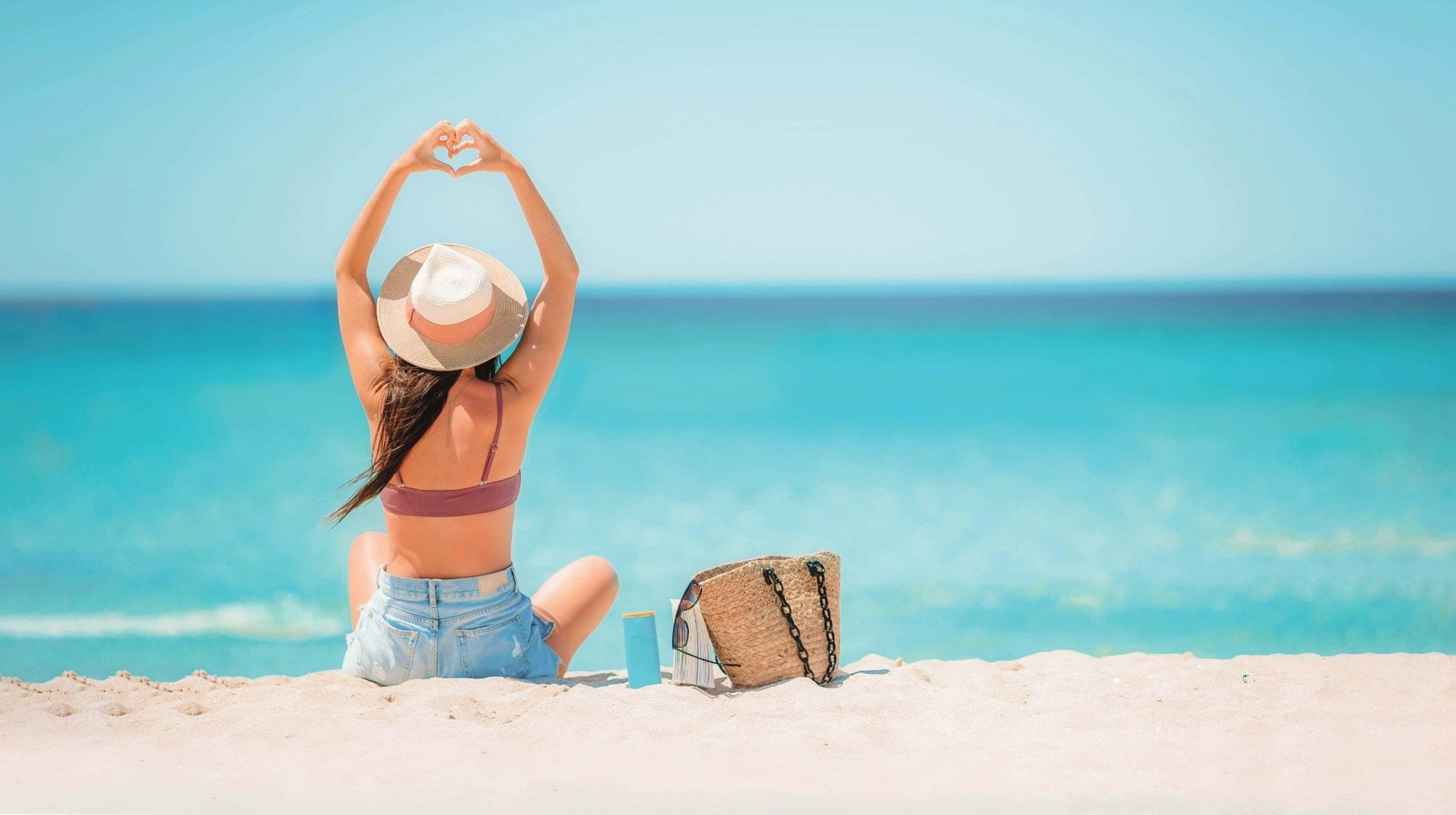 una mujer camina por la playa con la palabra soul escrita en la arena