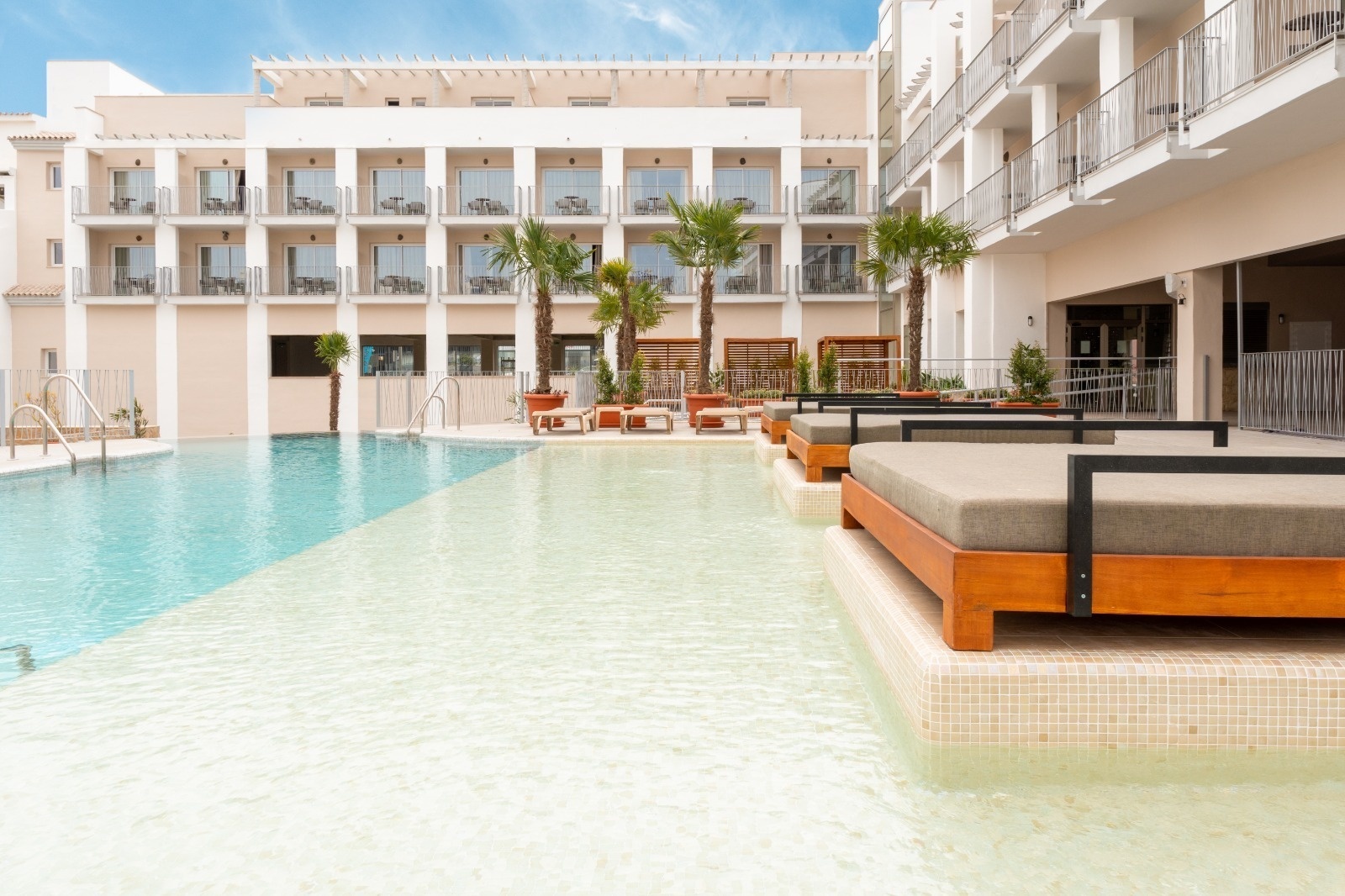 a hotel with a large swimming pool in front of it