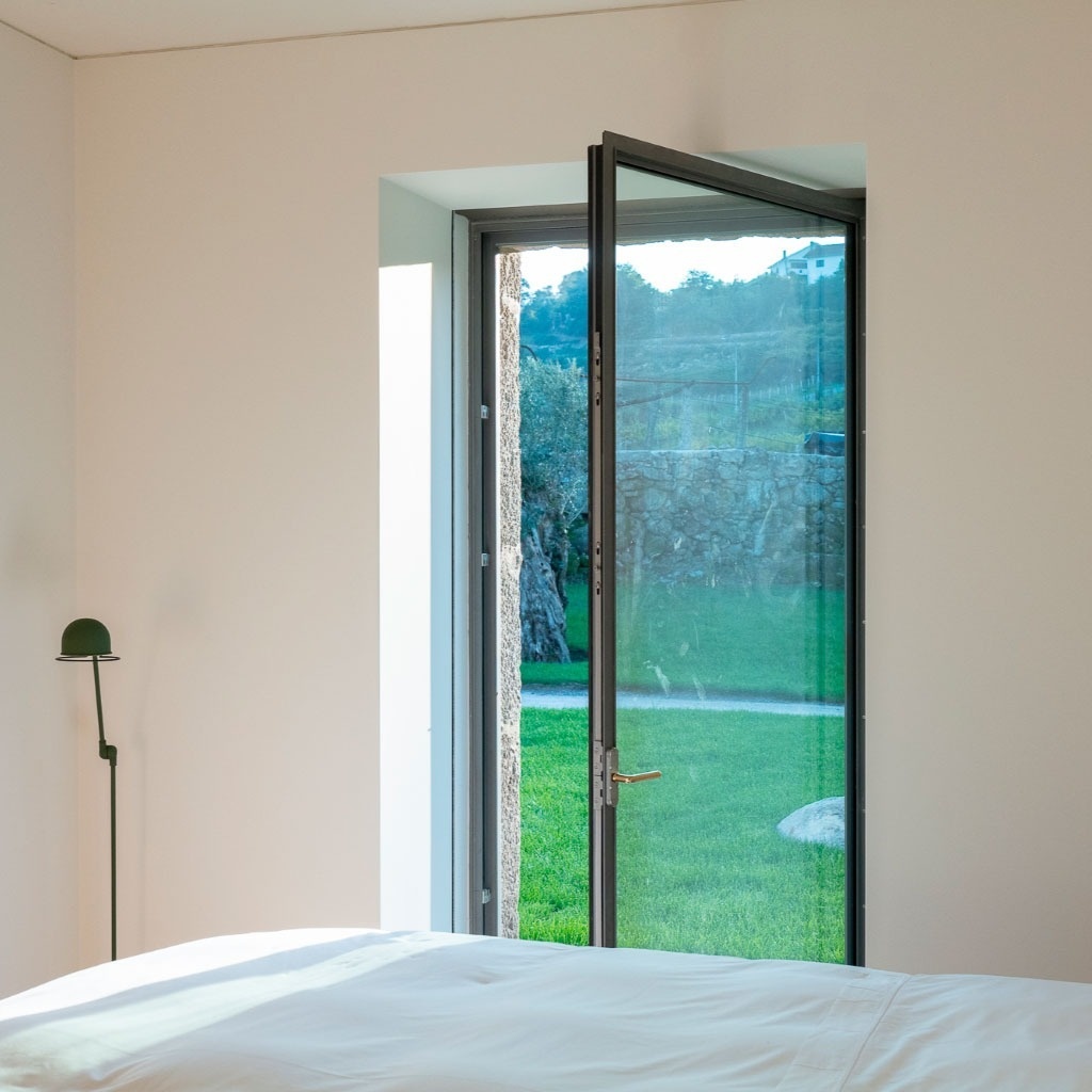 um quarto com uma cama e uma janela aberta