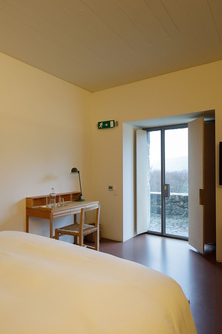 um quarto com uma mesa de madeira e uma cadeira