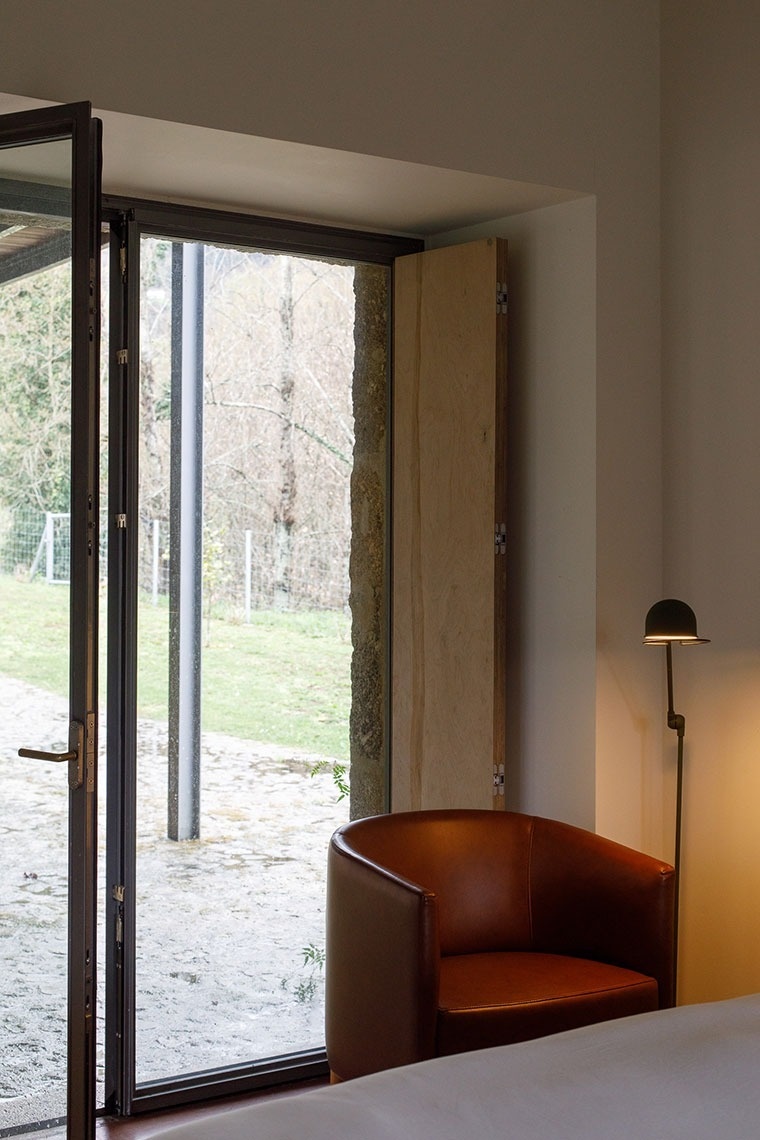 uma cadeira marrom está ao lado de uma janela aberta