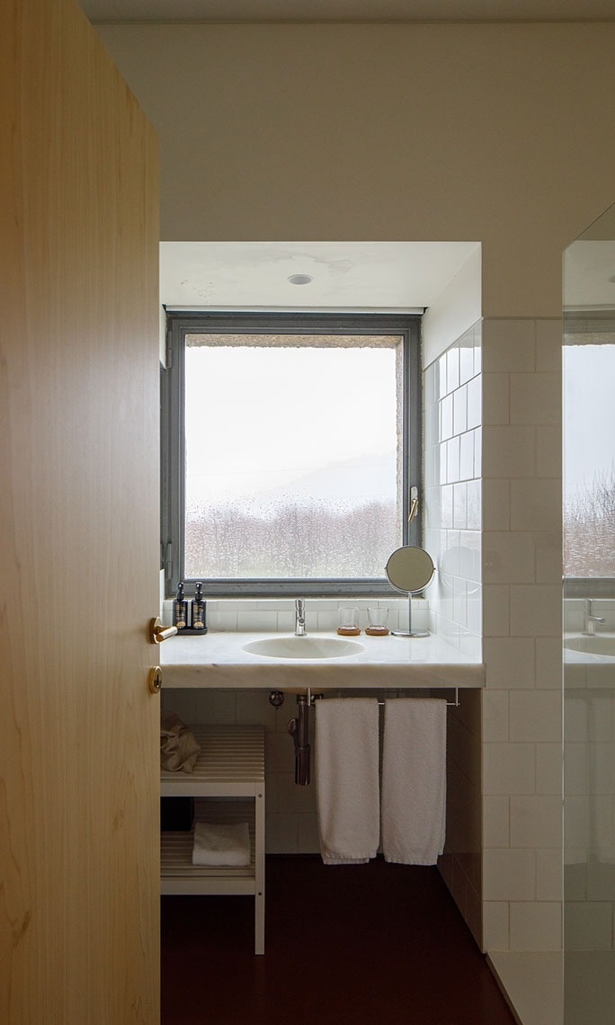 um banheiro com pia e espelho e uma janela