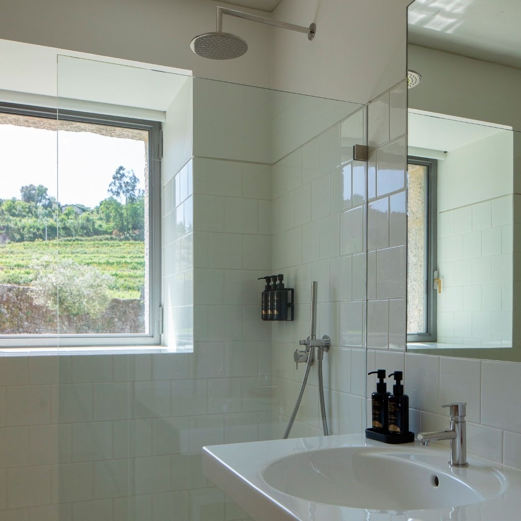 um banheiro com pia e chuveiro e uma janela