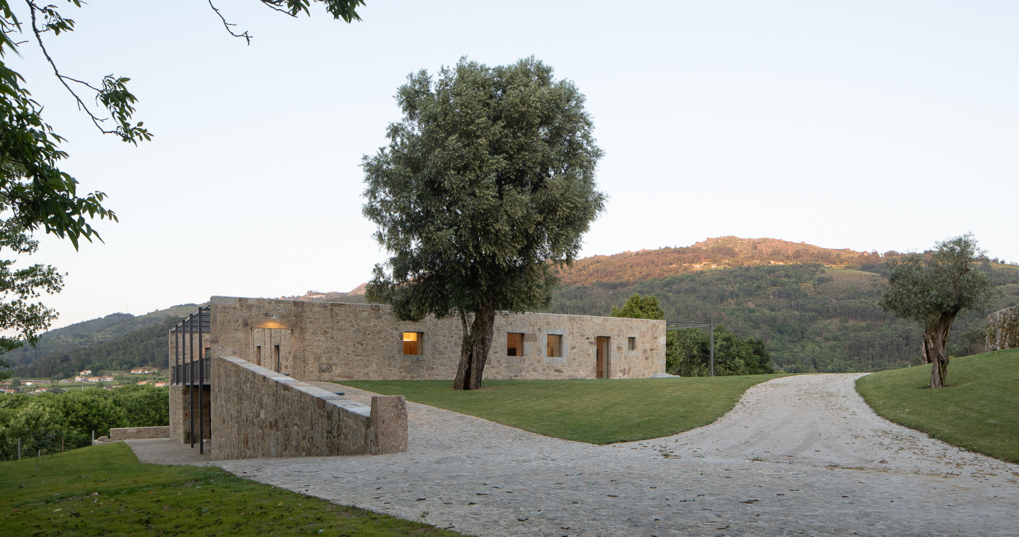 uma estrada de terra que leva a uma casa de pedra
