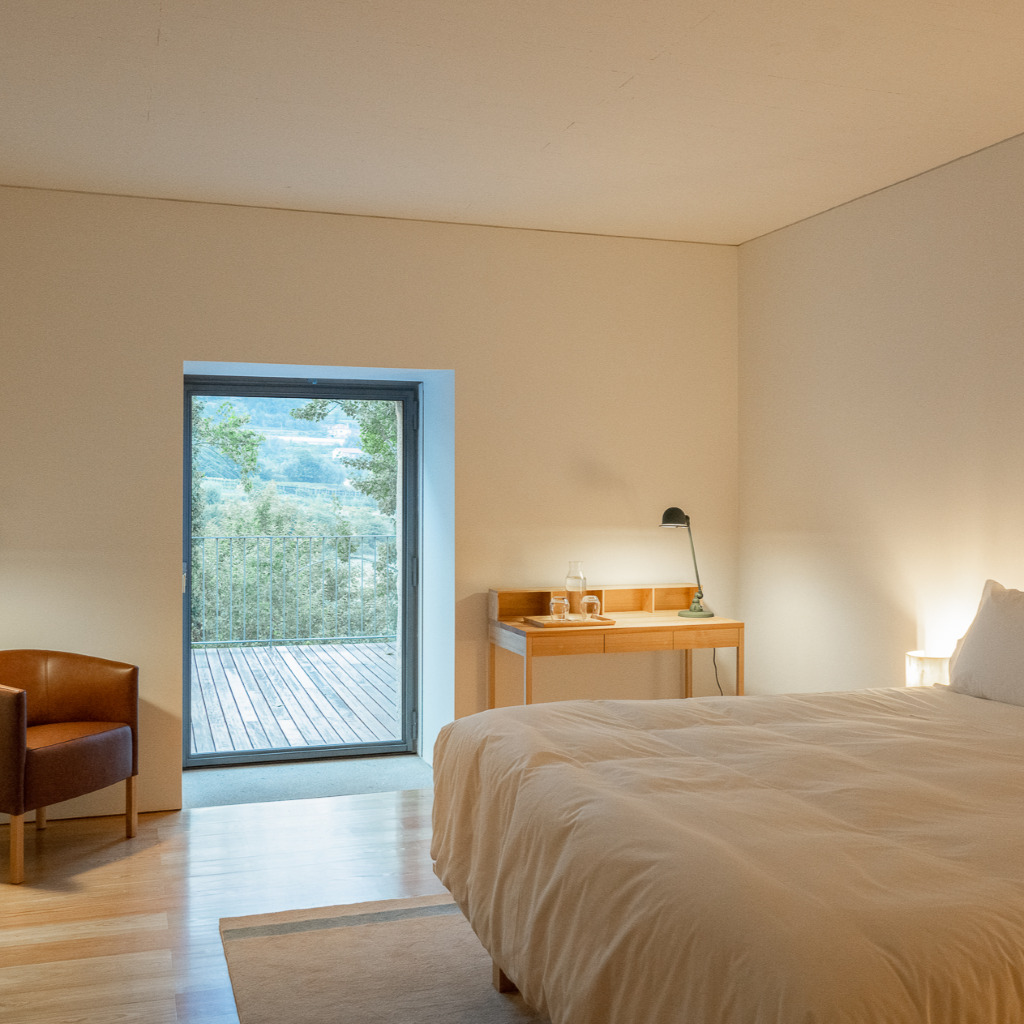 um quarto com uma cama e uma mesa e uma janela