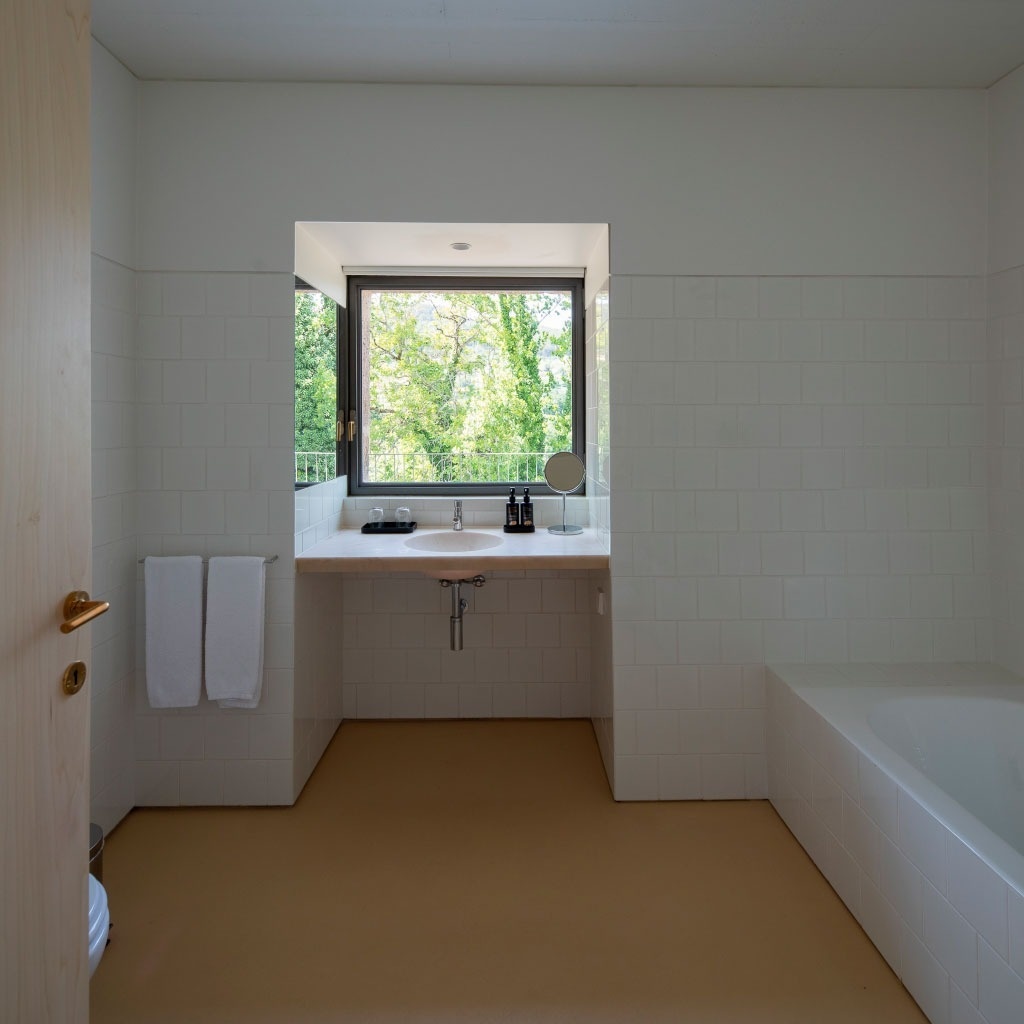 um banheiro com pia e banheira e uma janela