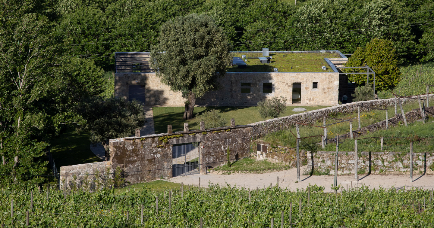 uma casa de pedra com um telhado verde