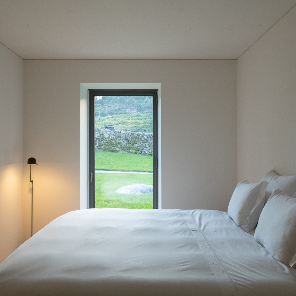 um quarto branco com uma cama e uma janela