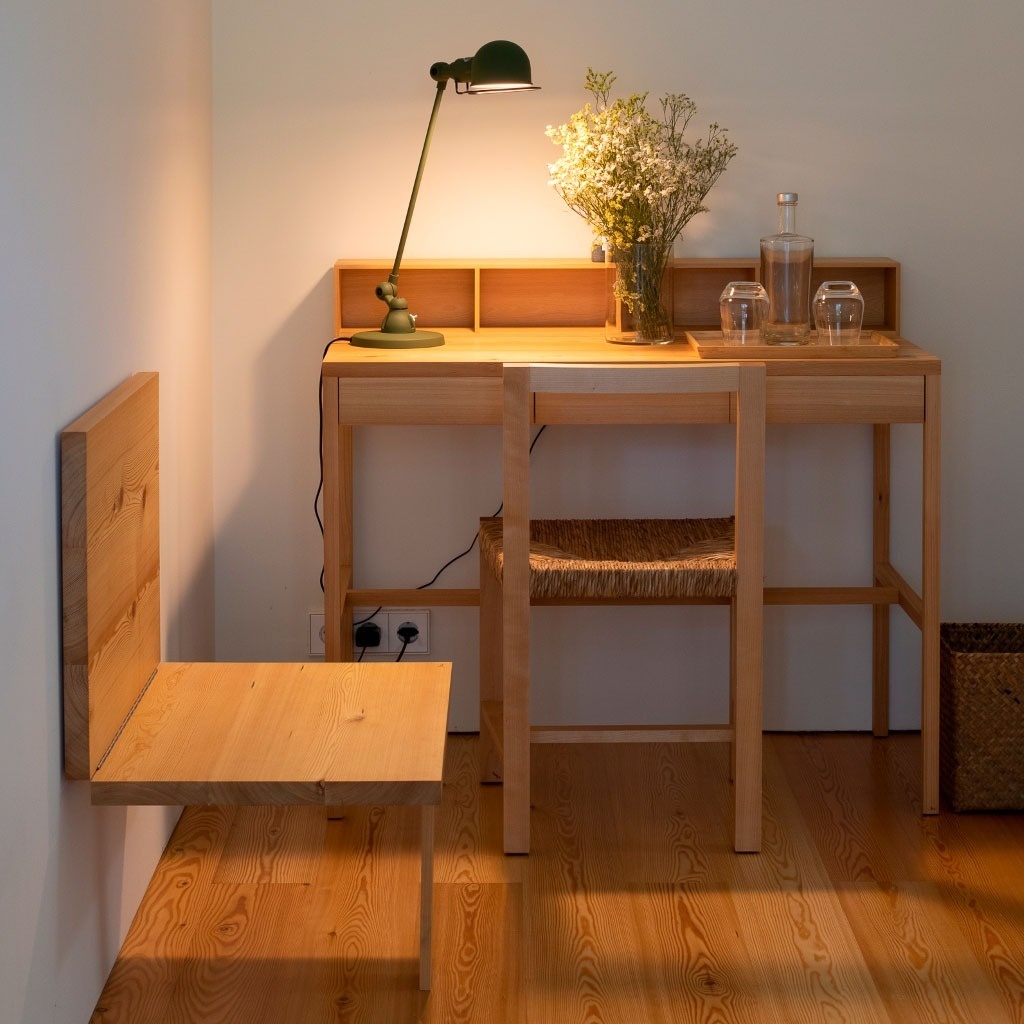 uma mesa de madeira com vaso de flores e uma garrafa de água
