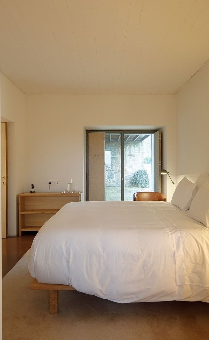 um quarto com uma cama e uma porta de vidro