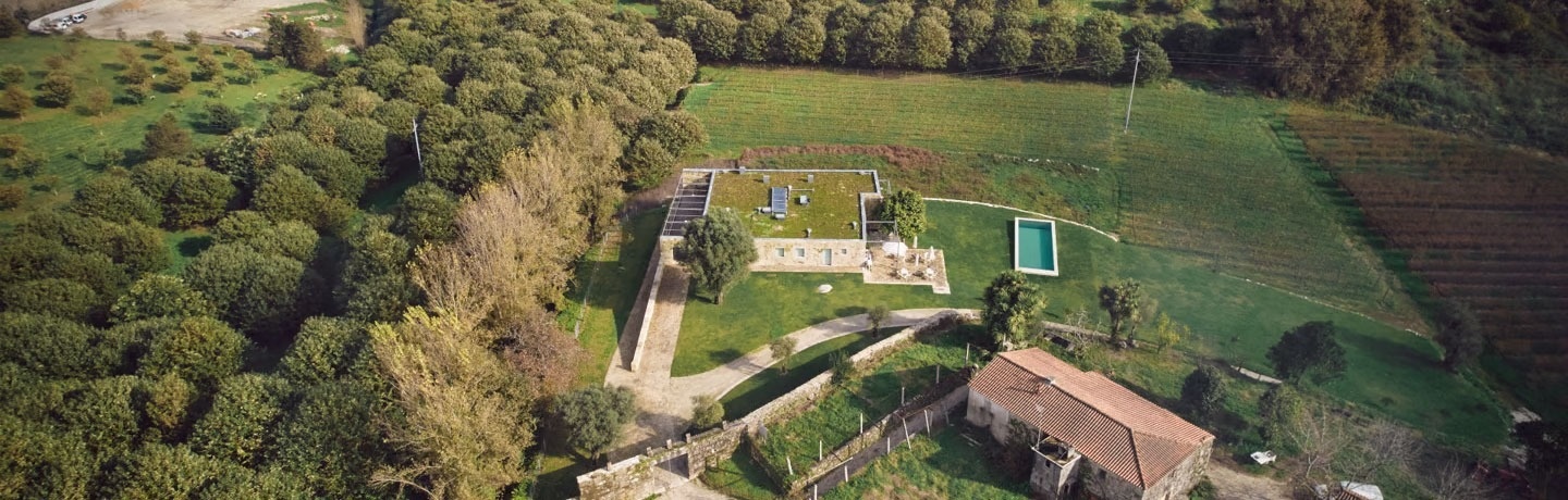 uma vista aérea de uma casa cercada por árvores e uma piscina