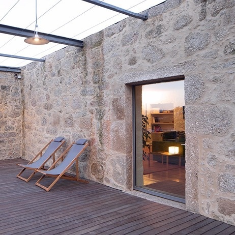 duas cadeiras de praia ao lado de uma parede de pedra