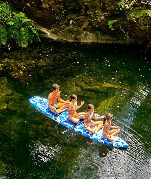 um homem e duas crianças estão sentados em um caiaque na água