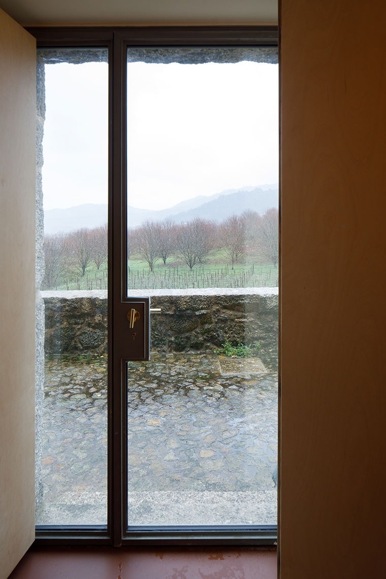 uma porta de vidro com uma vista de um campo e montanhas ao fundo