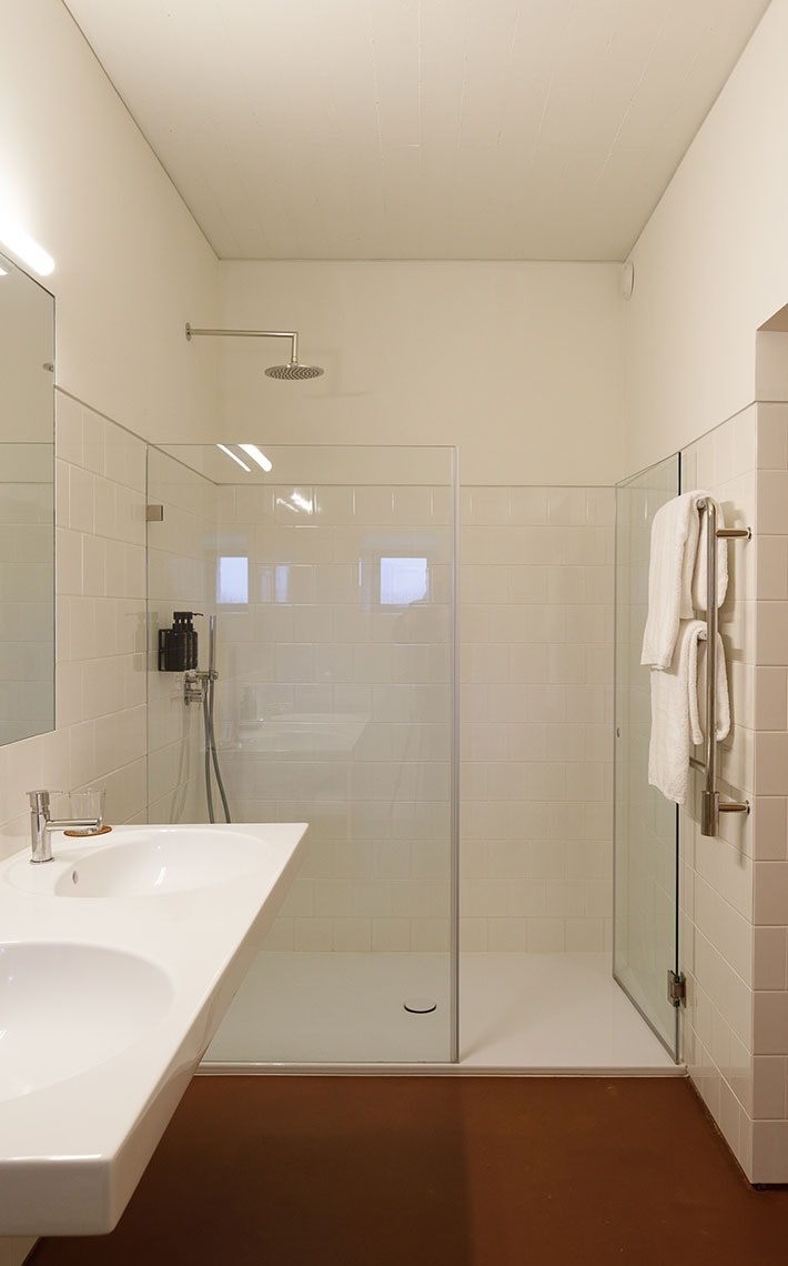 um banheiro com duas pias e um chuveiro de vidro