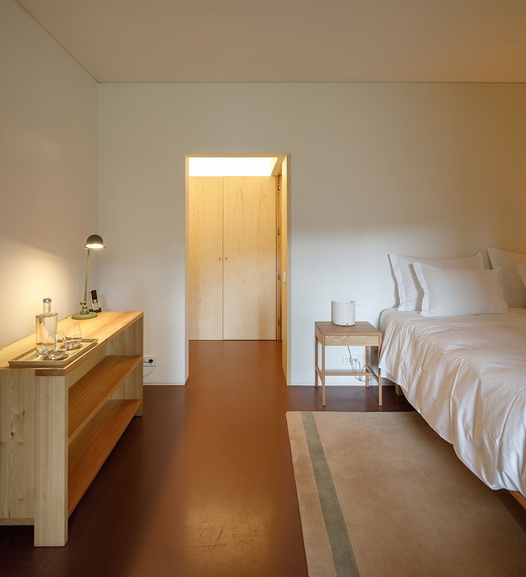 um quarto com uma cama e uma mesa de madeira