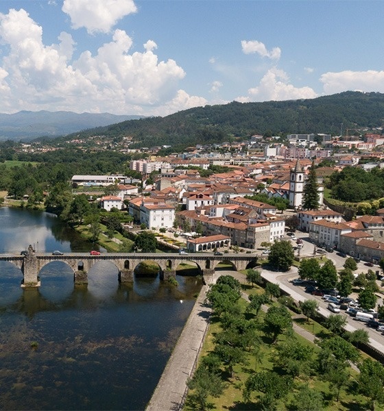 uma ponte sobre um rio com uma cidade ao fundo