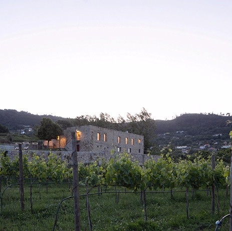 um prédio de pedra está ao lado de um vinhedo