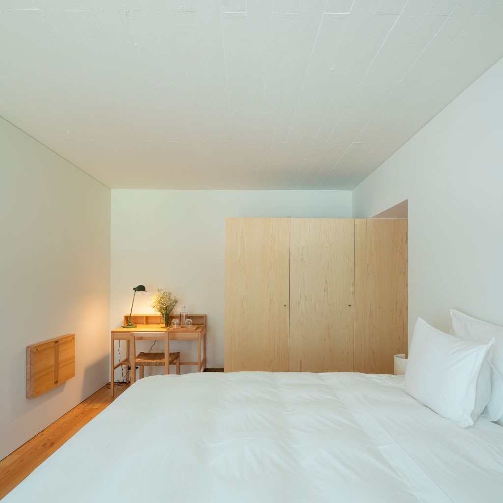 um quarto com uma cama e uma mesa de madeira