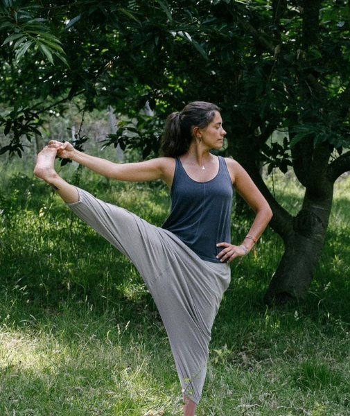 uma mulher está fazendo uma pose de ioga na grama