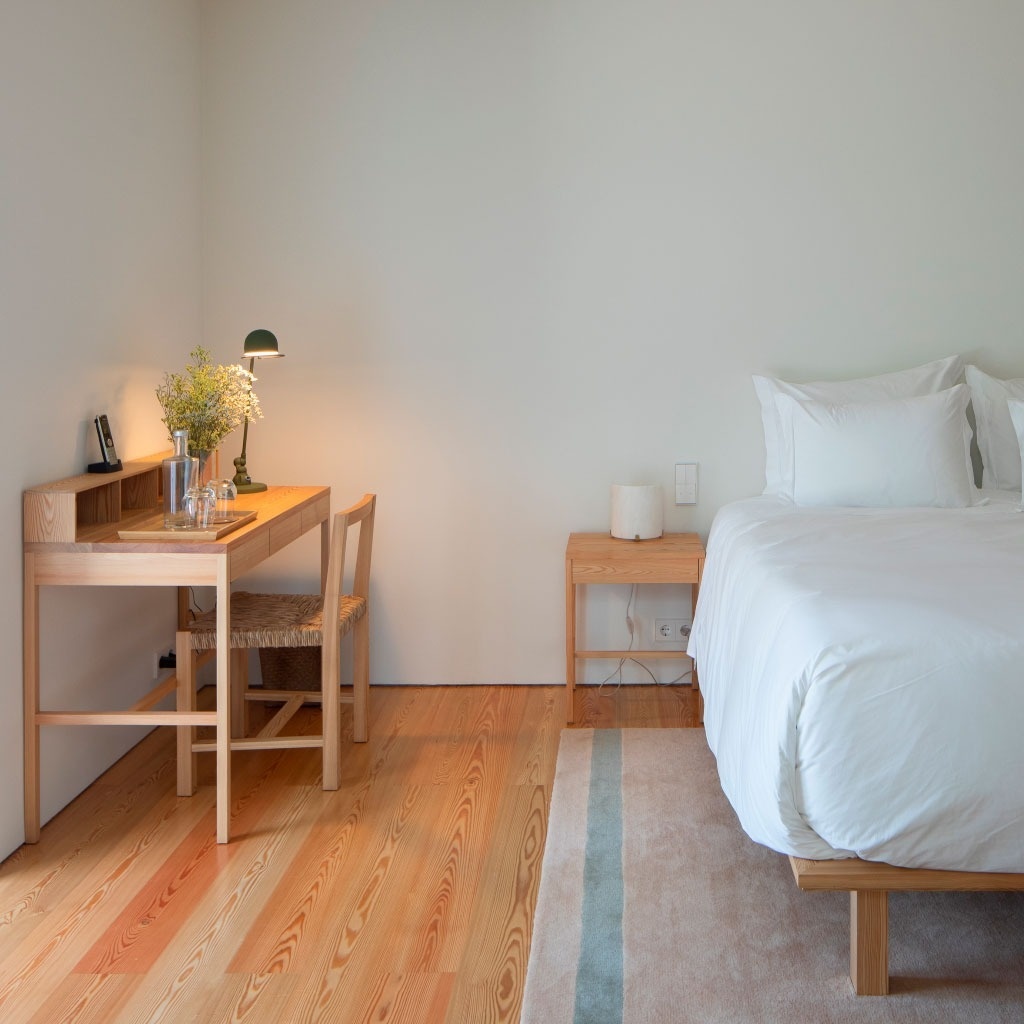 um quarto com uma cama e uma mesa de madeira