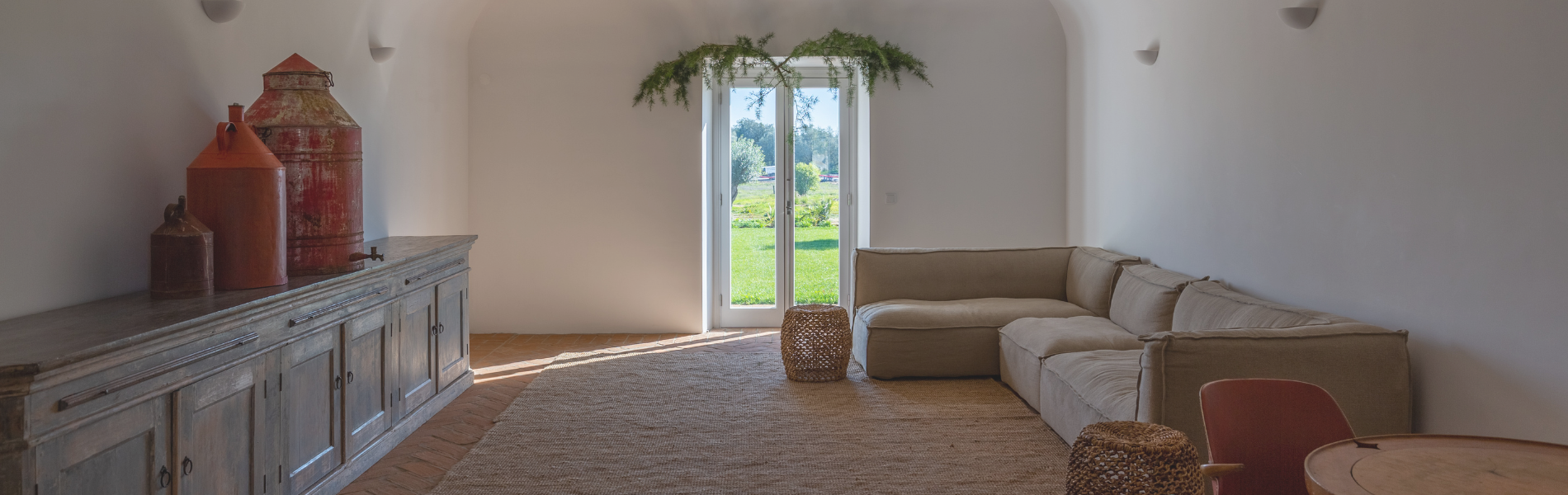 uma sala com sofá e cadeiras e um grande espelho