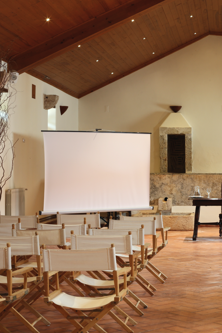 rows of director 's chairs in front of a projector screen