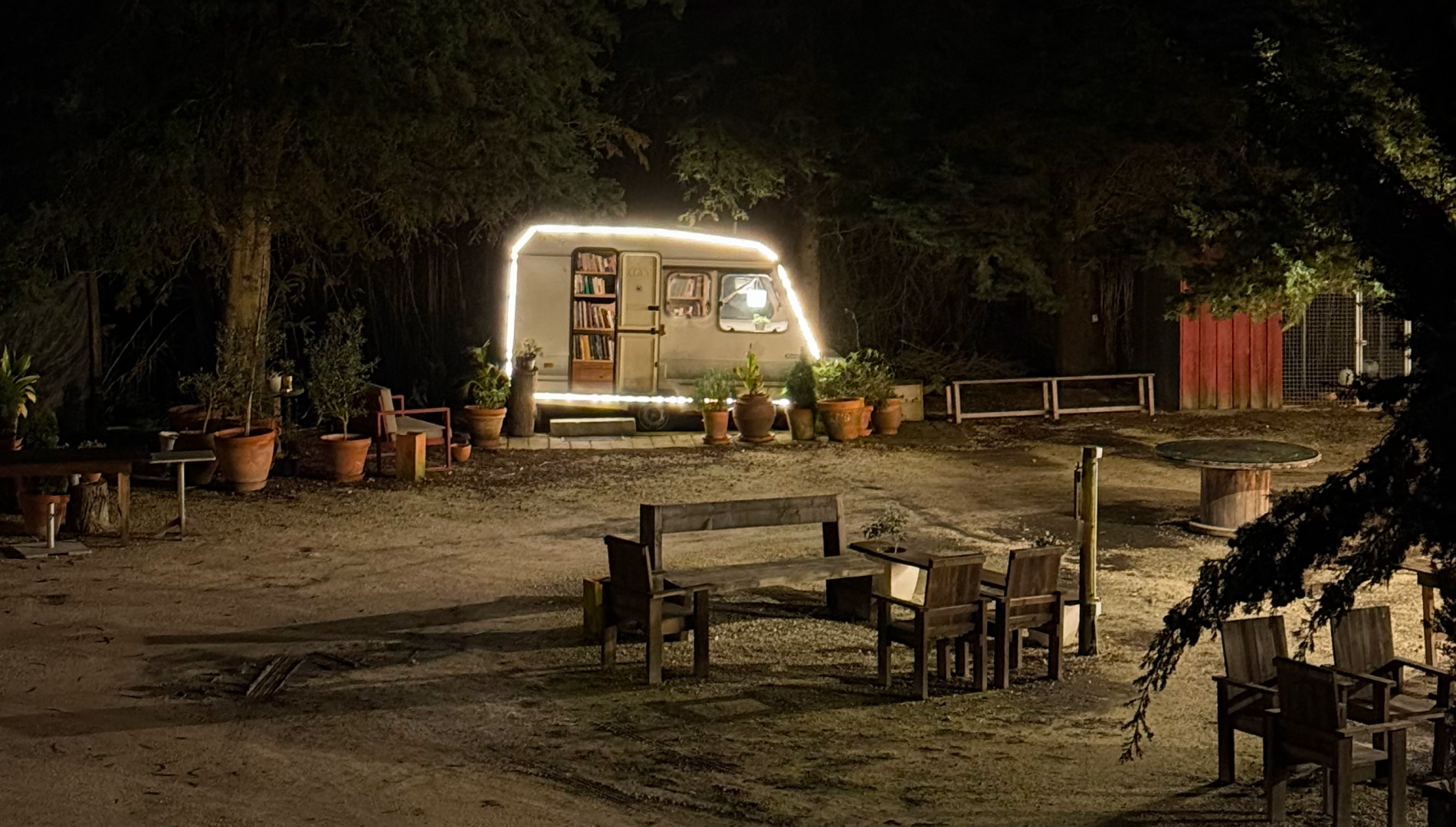 a trailer with a bookshelf on the side is lit up at night