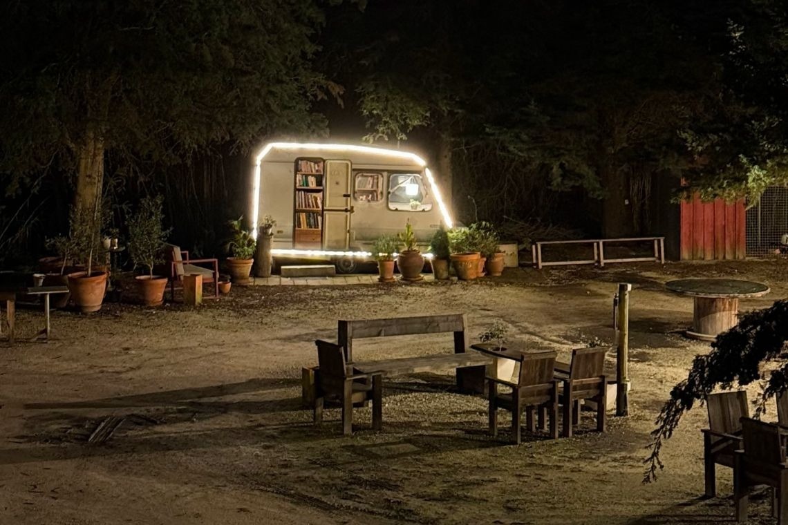 a trailer with a bookshelf on the side is lit up at night