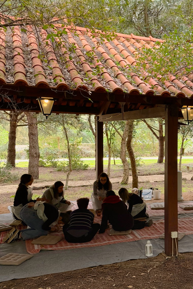 a group of people sitting on blankets under a roof