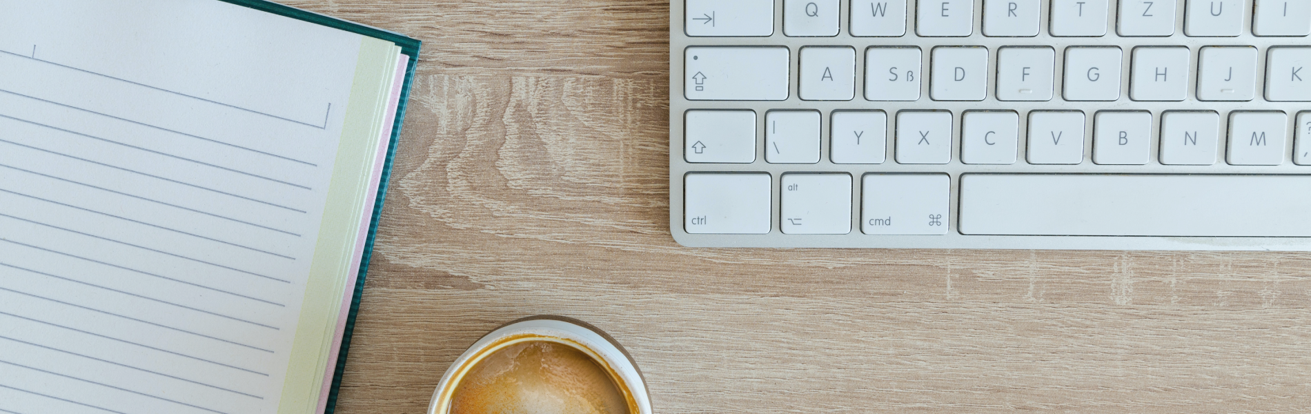 uma xícara de café está sobre uma mesa ao lado de um teclado