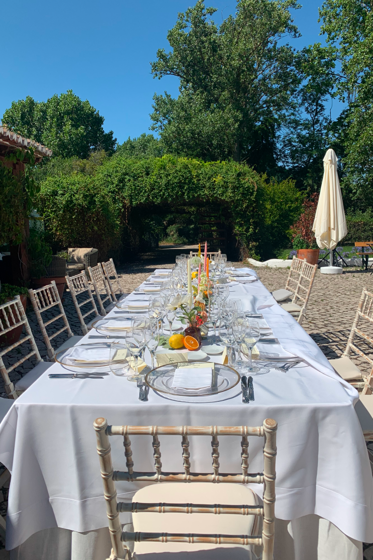 a long table with a white table cloth and chairs