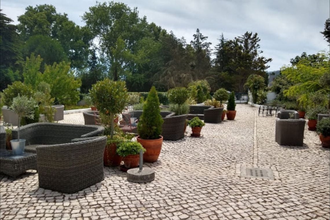 a patio with wicker chairs and potted plants