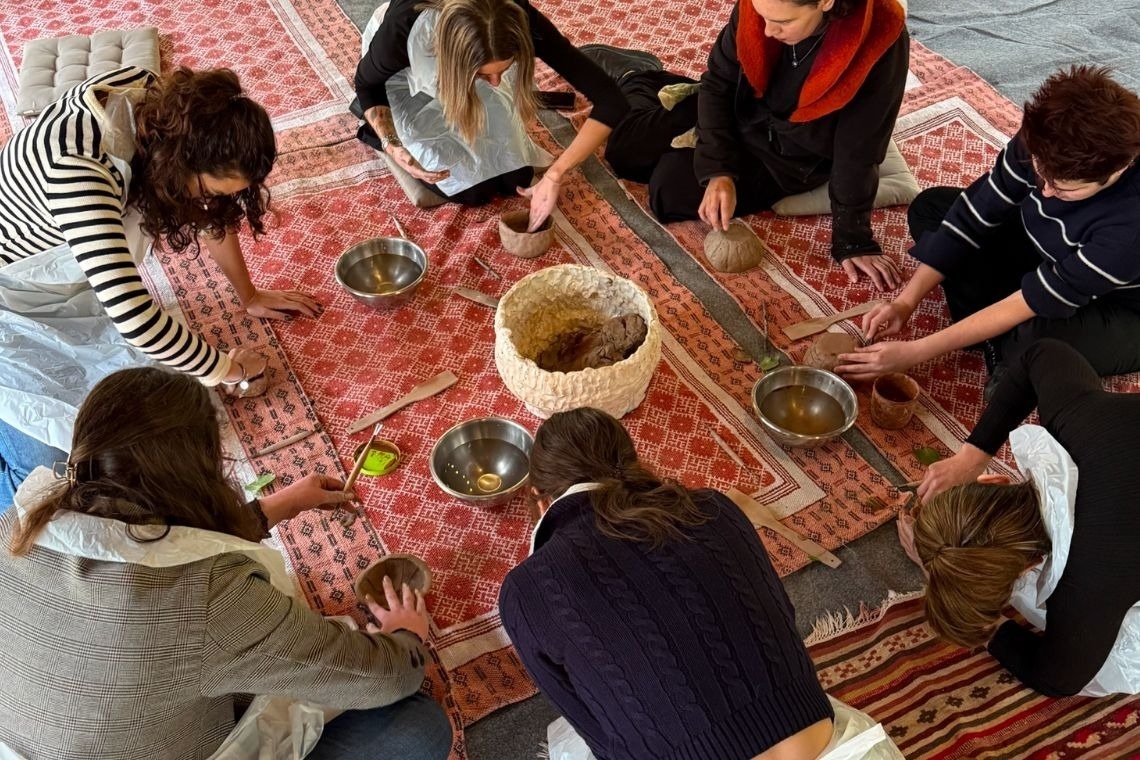 a group of people are sitting around a table with bowls on it