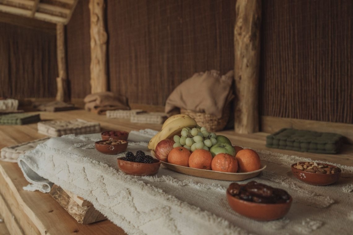 a table with bowls of fruit and nuts on it