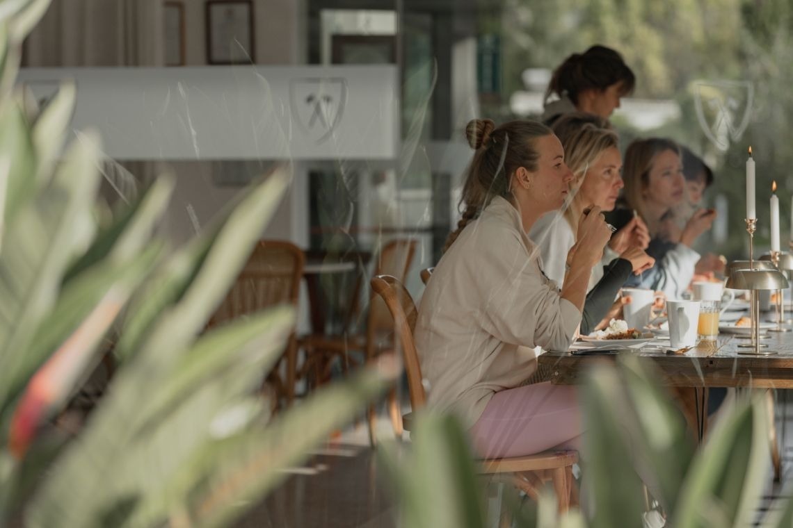 a group of people are sitting at a table in a restaurant
