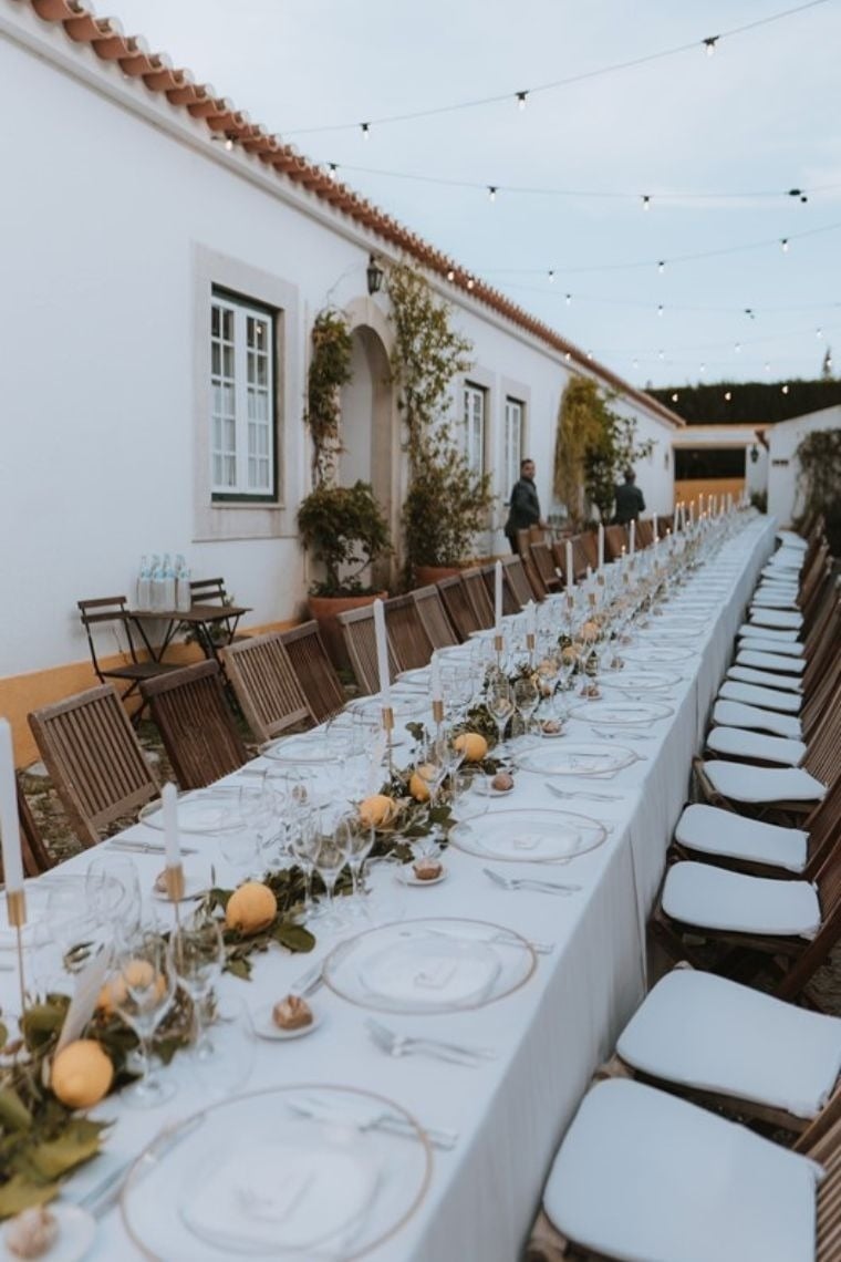 a long table with plates and candles on it