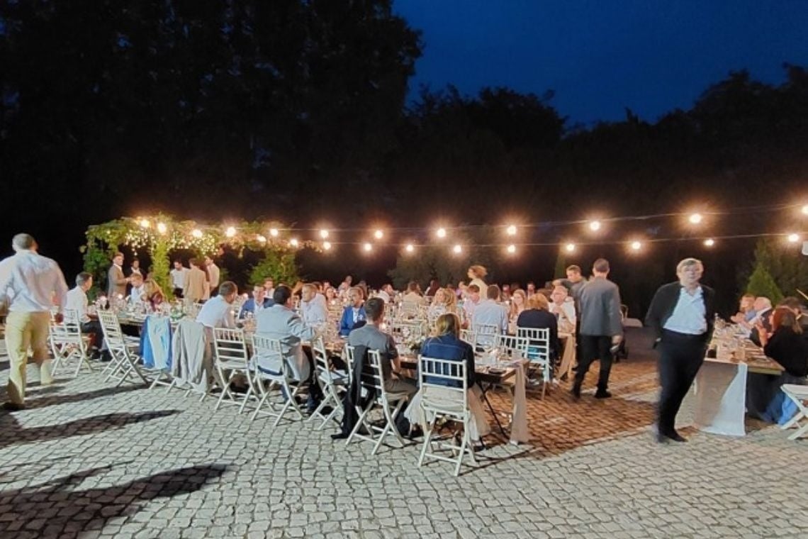 a group of people sitting at tables outside at night