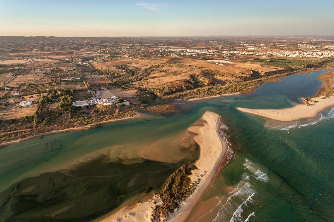 Vista aérea da Quinta dos Perfumes, Algarve, com rio e mar.