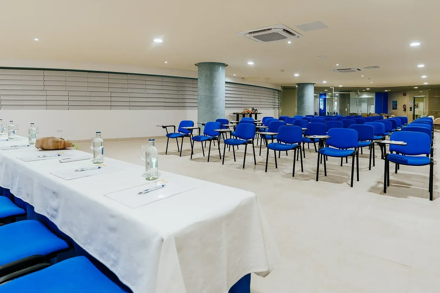 R2 Hotels Konferenzraum für Unternehmen: blaue Stühle und Tisch.