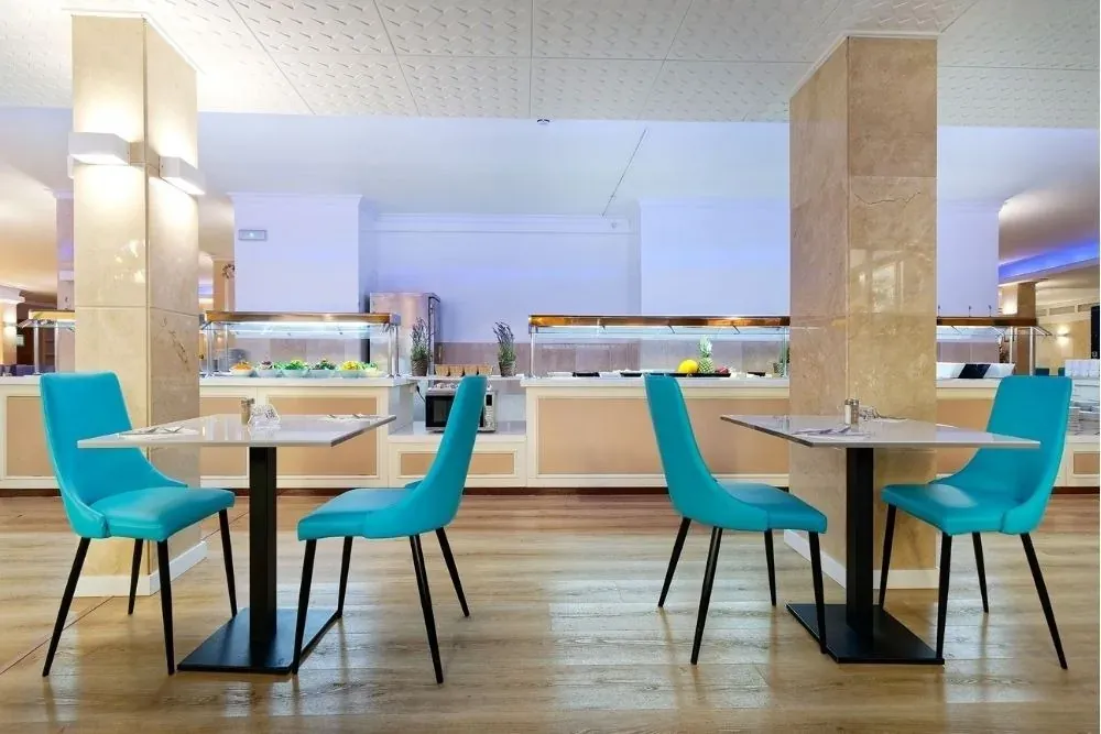 Comedor R2 Hoteles: mesas y sillas turquesas en buffet